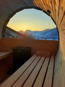 una ventana exterior de una sauna con puesta de sol en Chata Natura, en Muszyna