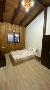 a bedroom with a bed and a chandelier at Casa de lemn in Corbu