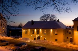 uma casa com carros estacionados na neve à noite em Pension und Gaststätte "Zur Brauschänke" em Schöneck