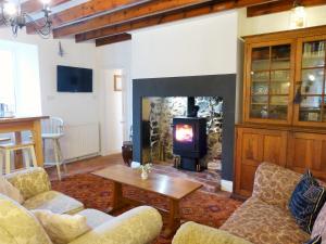 un salon avec une cheminée et un poêle dans l'établissement Roman Cottage - - Hadrian's Wall dark sky outpost., à Newcastle upon Tyne