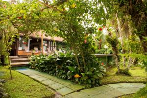 a house with a bunch of plants in the yard at Pousada Éphira in Ilha do Mel