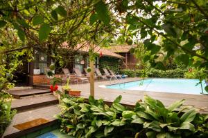 uma piscina com cadeiras e uma casa em Pousada Éphira na Ilha do Mel