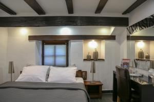 a bedroom with a bed with white pillows and a table at Auberge Aal Veinen in Vianden