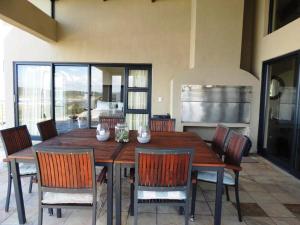a dining room with a wooden table and chairs at Whalesong Villa in Hermanus