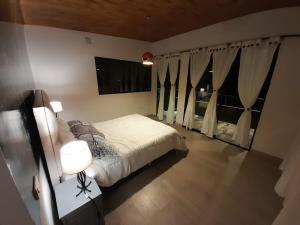 佩雷拉的住宿－Cabaña miramar，一间卧室设有一张床和两个窗户。