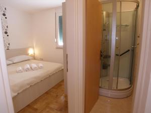 a bedroom with a shower and a bed with white sheets at Apartments Marina in Vodice +97 photos