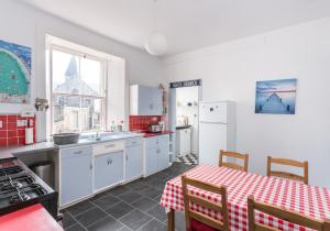 a kitchen with white appliances and a table with a table cloth at The Gulls in North Berwick