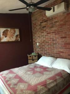 um quarto com uma cama com uma parede de tijolos em Habitación Potter em Cancún