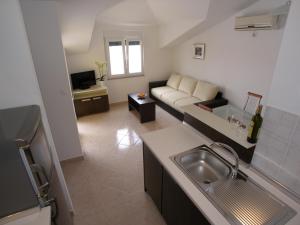 a kitchen and living room with a couch and a sink at Apartments Marina in Vodice