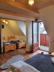 a room with two beds and an open door at Willa U Kantora in Murzasichle