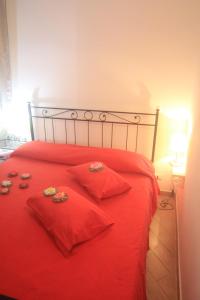 a red bed with red pillows and shoes on it at Vernazza Vacation 2 in Vernazza