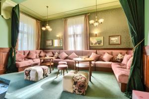 a living room with a pink couch and tables at Villa Antica in Kudowa-Zdrój