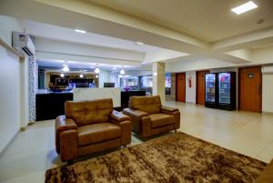 two chairs and a rug in a lobby with a counter at Novares Hotel in Goiânia