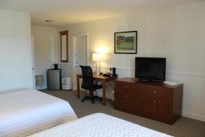 ein Hotelzimmer mit einem Bett und einem Schreibtisch mit einem TV in der Unterkunft Shenvalee Golf Resort in New Market