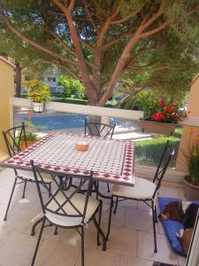 a table and chairs on a patio with a dog sleeping at DUPLEX CAP D AGDE PISCINE in Cap d'Agde +1 photo