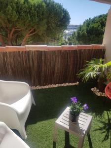 a patio with a table and a chair and flowers at DUPLEX CAP D AGDE PISCINE in Cap d'Agde