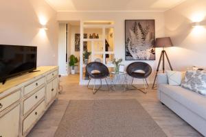 a living room with a couch and two chairs at BEACHOME4U3 in Carcavelos