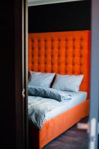 ヴィーンヌィツャにあるЭксклюзивная квартираのベッド(オレンジ色のヘッドボード、白い枕付)