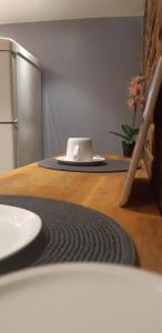 Le Raincy的住宿－DOUX COCON DE 50 m2 PARIS-LE RAINCY，厨房配有带冰箱和盘子的桌子