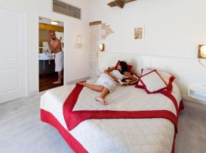 a woman laying on a bed in a bedroom at Hôtel Restaurant & Spa Plaisir in Le Bois-Plage-en-Ré