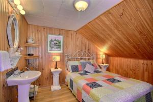 a bedroom with a bed and a sink at Les Gites Makadan in Normandin