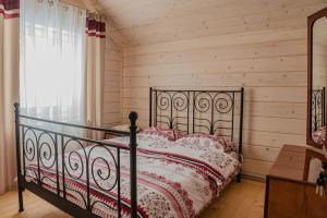 a bed in a room with a wooden wall at Кільце Карпат in Verkhniy Yasenov