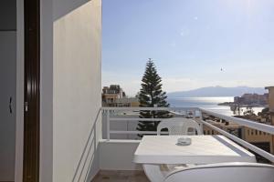 balcón con mesa, sillas y vistas al océano en Star Hotel Saranda, en Sarandë