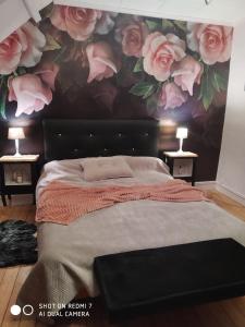 een slaapkamer met een bed met een bloemenmuur bij Le Cati Mini in Cancale