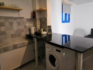 a laundry room with a washing machine and a counter at The Blue Gate in Muscat