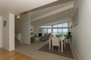 a dining room and living room with a table and chairs at Doubtless Bay Retreat 