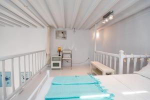 ミコノス・シティにあるTraditional Split level house in Mykonos Townの白いベッドルーム(ベッド1台、デスク付)