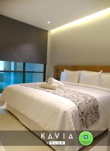 a bedroom with a large bed with white sheets at Hotel Kavia Plus in Cancún