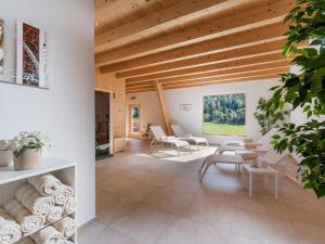 イッターにあるHotel Edelweissの木製の天井と白い家具が備わるリビングルーム