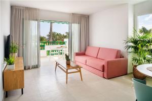 a living room with a pink couch and a table at Nazaret Apartments in Costa Teguise