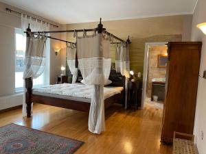 Schlafzimmer mit Himmelbett und weißen Vorhängen in der Unterkunft Park Villa Gernsheim in Gernsheim