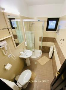 a bathroom with a toilet and a sink and a shower at Pensiunea Camena in Piatra Neamţ