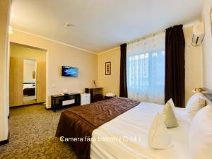 a hotel room with a large bed and a window at Pensiunea Camena in Piatra Neamţ