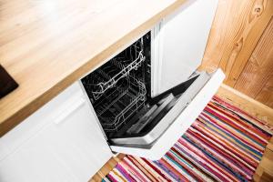 an oven with its door open on a kitchen floor at Beach House in Lège-Cap-Ferret