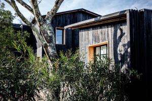 a wooden house with a tree in front of it at Beach House in Lège-Cap-Ferret