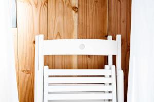 a white chair sitting next to a wooden wall at Beach House in Lège-Cap-Ferret