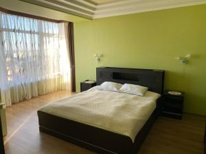 a bedroom with a bed and a large window at Luxury apartment 2 in Truskavets