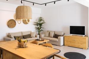 - un salon avec un canapé et une table dans l'établissement Amer Villa Santorini with outdoor hot tub, à Vóthon