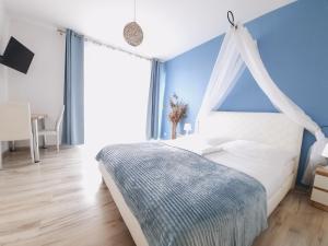 1 dormitorio con cama blanca y pared azul en Willa Baltycka Bryza en Władysławowo