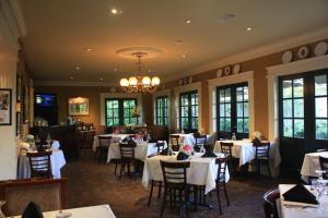 una sala da pranzo con tavoli e sedie bianchi di Anchuca Historic Mansion & Inn a Vicksburg