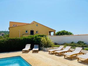 a group of lounge chairs next to a swimming pool at Résidence Marie Diane - Laurier des Montagnes in Propriano