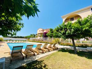 a row of chairs sitting next to a swimming pool at Résidence Marie Diane - Laurier des Montagnes in Propriano