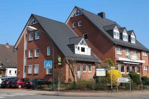 a large red brick building with a black roof at Hotel Stadtidyll & Dependancen in Rotenburg an der Wümme