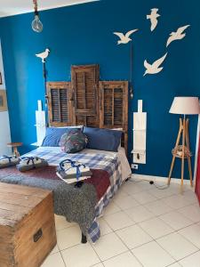 a bedroom with a bed with birds on the wall at Casetta del borghetto -Nel cuore del Borghetto in Nettuno
