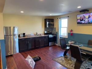 a kitchen with a refrigerator and a table with chairs at JD Apartment and House in Seaside Heights