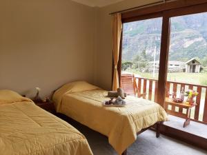 a bedroom with two beds and a balcony at La Posada de Gocta in Cocachimba